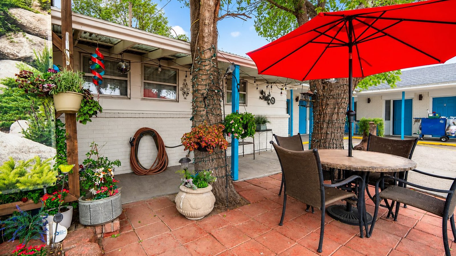 A shaded patio at Capri Motel with seating and flowers