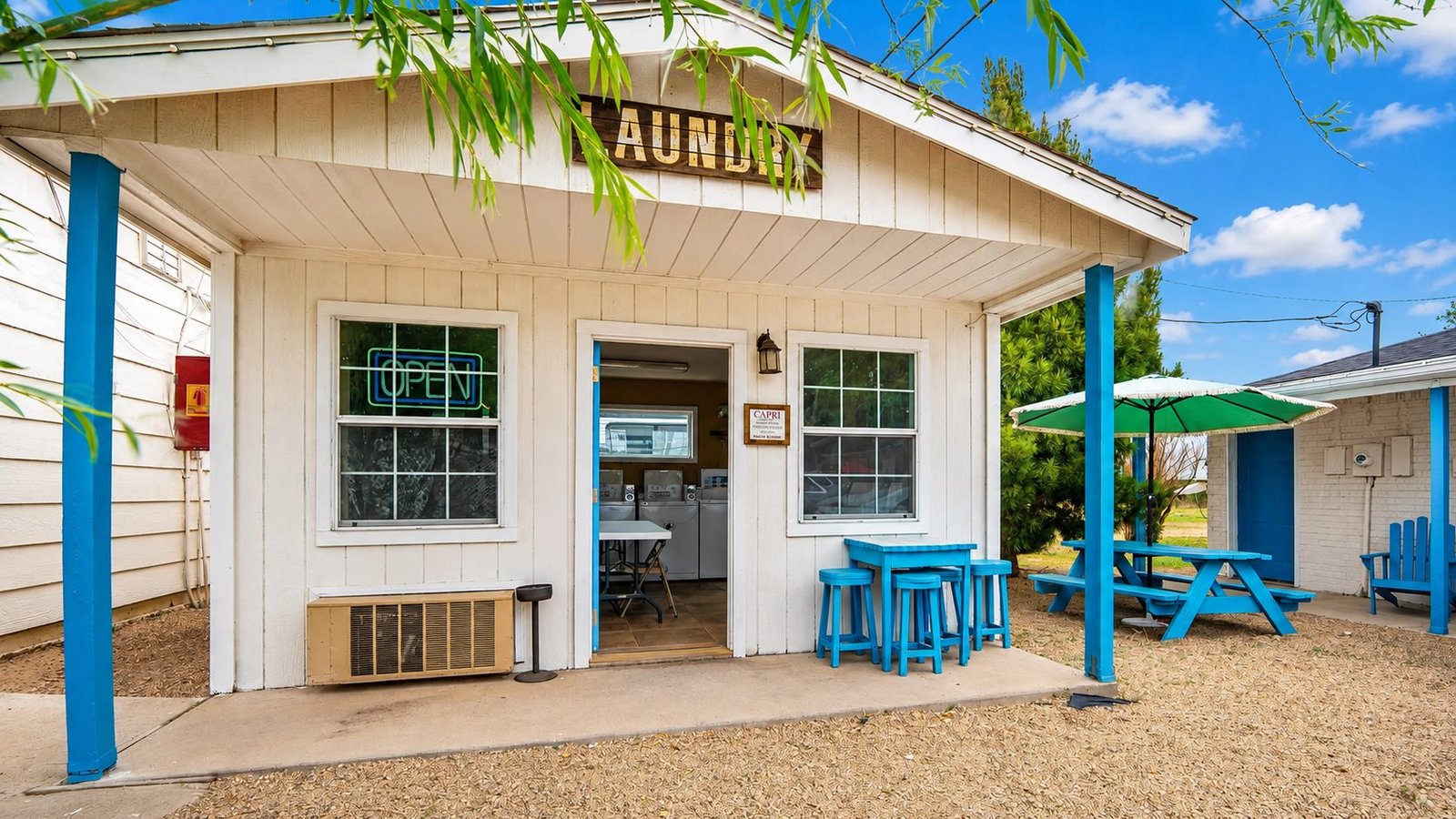White laundry building with bright blue trim on the Capri Motel property